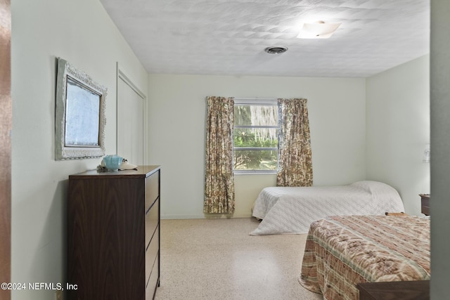 bedroom featuring light speckled floor, visible vents, and baseboards