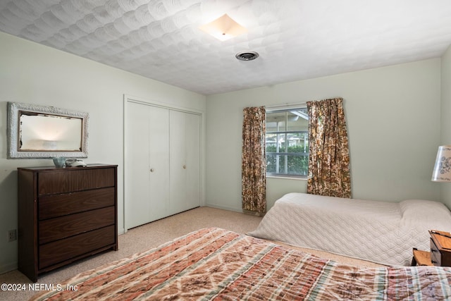 bedroom with light carpet and a closet