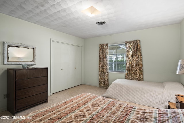 bedroom featuring baseboards, visible vents, and a closet