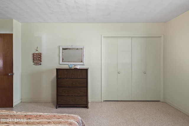 unfurnished bedroom with baseboards, light speckled floor, and a closet