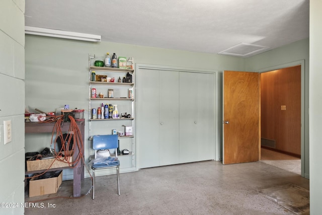 interior space featuring attic access, a closet, visible vents, and light speckled floor