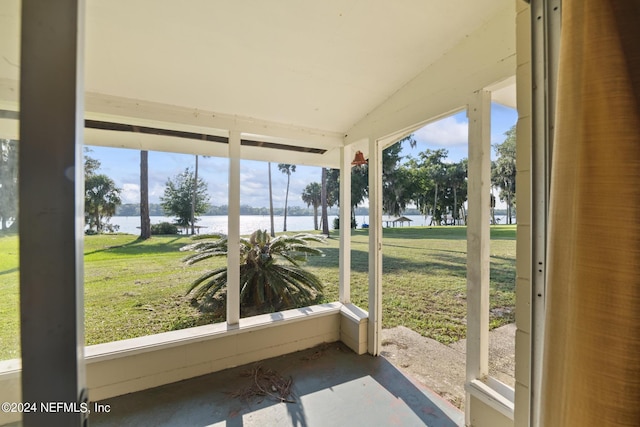 sunroom / solarium featuring lofted ceiling and a water view