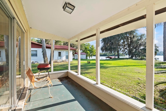 sunroom featuring a water view