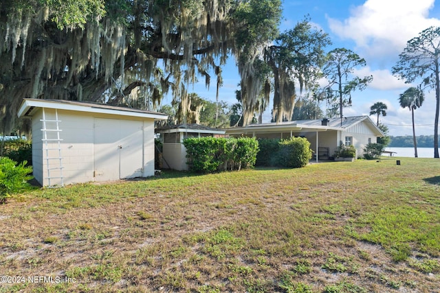 view of yard with a storage unit and a water view