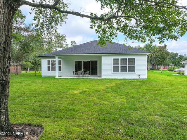 back of property featuring a patio area and a yard