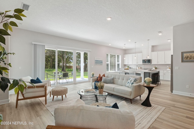 living room featuring a textured ceiling and light hardwood / wood-style floors