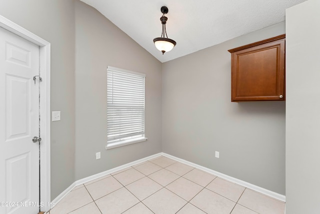 tiled empty room with lofted ceiling