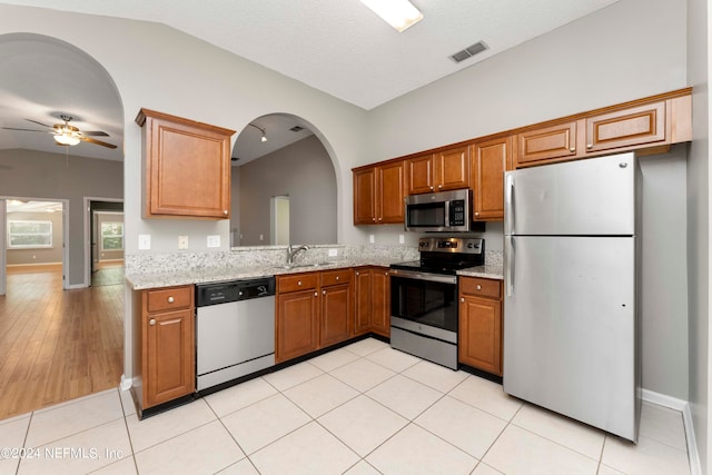 kitchen with light hardwood / wood-style flooring, stainless steel appliances, sink, lofted ceiling, and ceiling fan