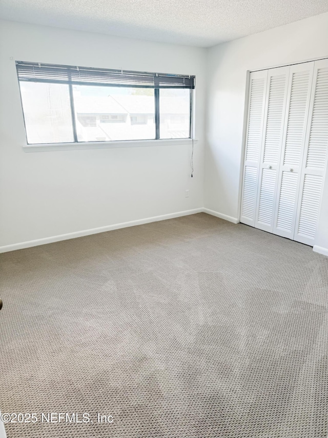 unfurnished bedroom featuring carpet floors, a closet, and a textured ceiling