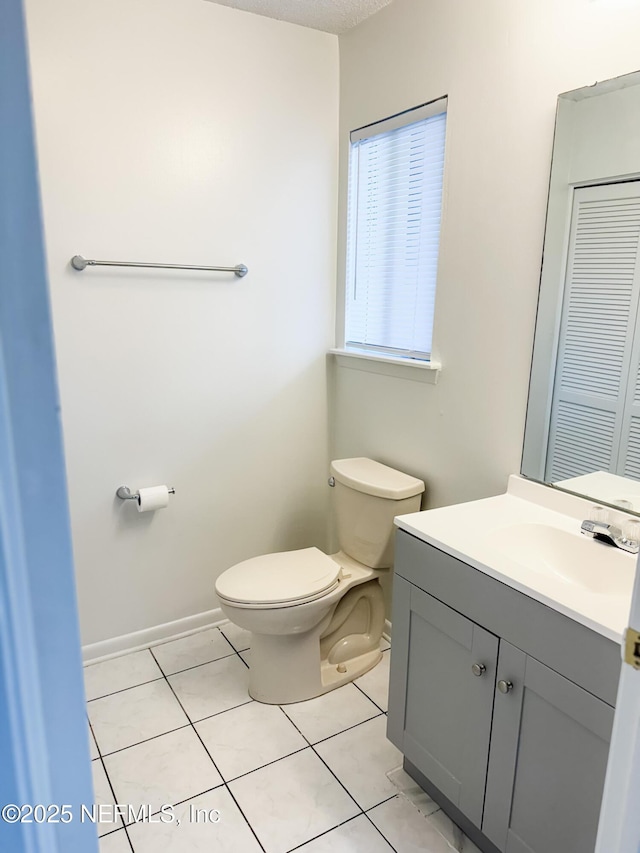 bathroom featuring toilet, tile patterned floors, and vanity