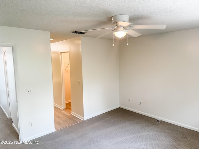 spare room featuring ceiling fan, a textured ceiling, and light carpet