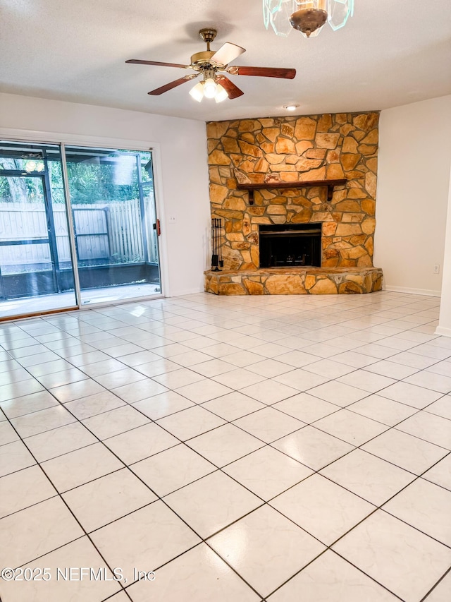 unfurnished living room featuring ceiling fan, light tile patterned floors, and a fireplace