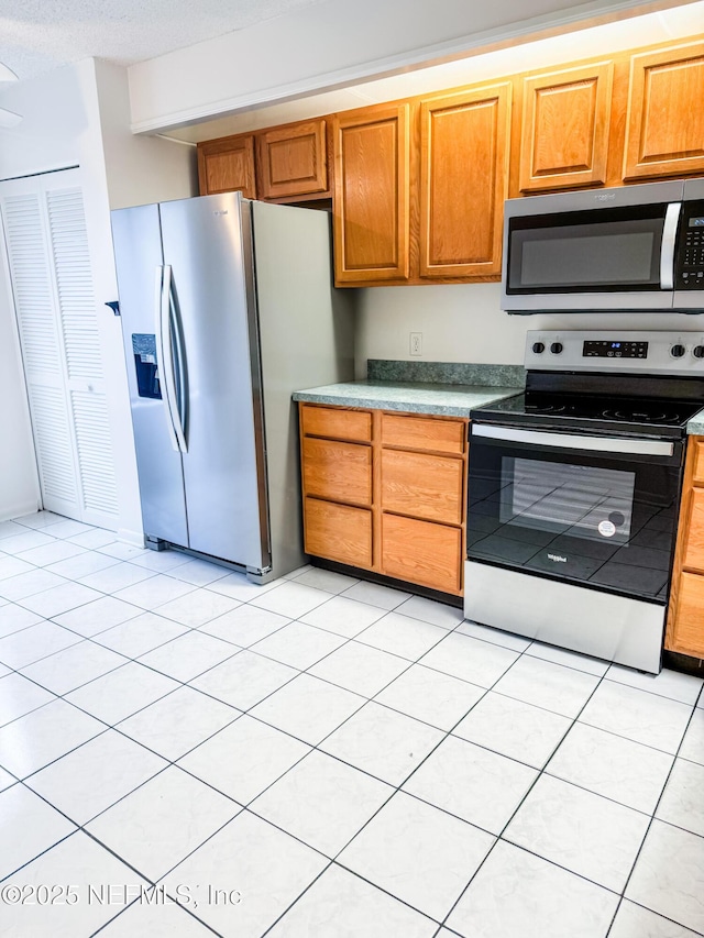 kitchen featuring light tile patterned floors and stainless steel appliances