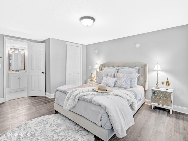 bedroom with sink, a closet, wood-type flooring, and ensuite bathroom