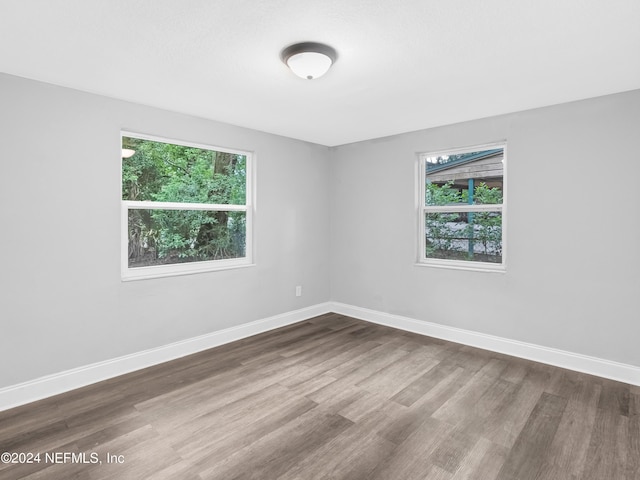 unfurnished room with wood finished floors and baseboards