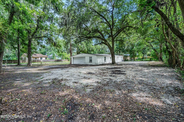 view of yard featuring a garage and fence