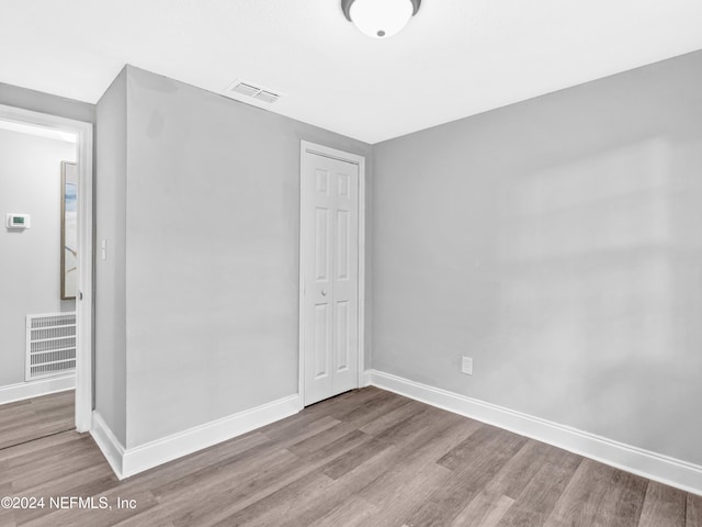 unfurnished bedroom featuring a closet and wood-type flooring