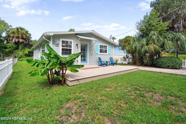 rear view of property with a patio, a lawn, and fence