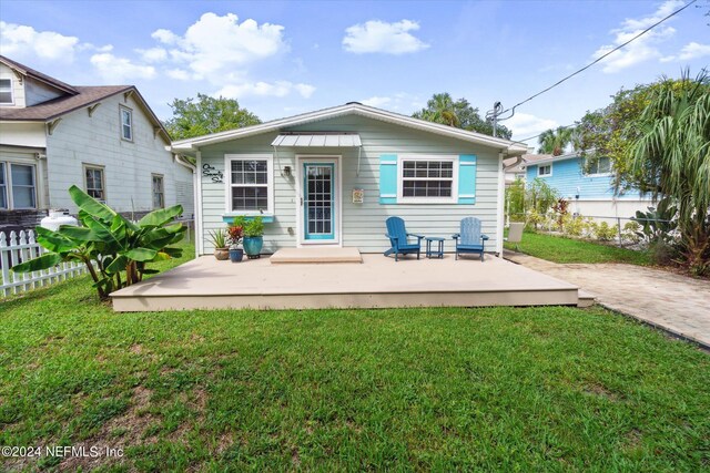 back of house featuring a lawn and a patio