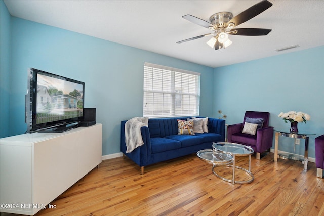 living room featuring ceiling fan, baseboards, visible vents, and light wood-style floors