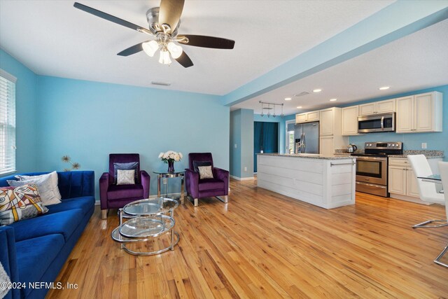 living room with ceiling fan and light wood-type flooring