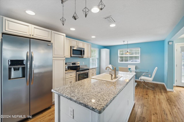 kitchen with light wood-style flooring, visible vents, stainless steel appliances, and a sink