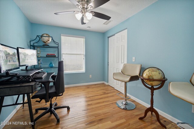 office space with light wood-type flooring, a textured ceiling, and ceiling fan