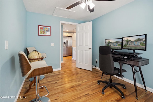 office featuring light wood finished floors, attic access, and baseboards