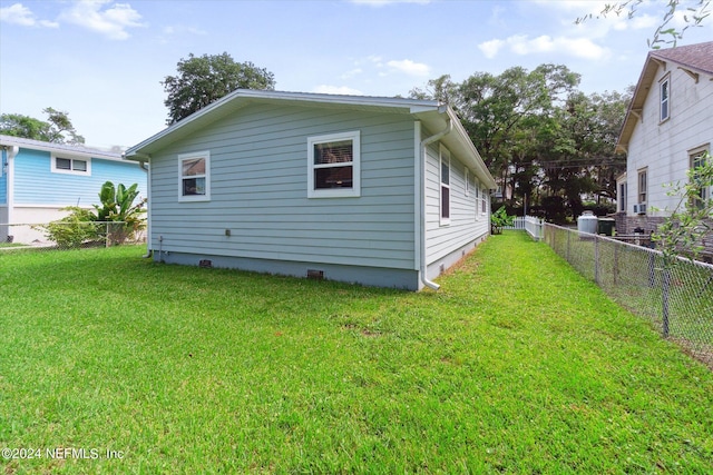 rear view of property with a yard and a fenced backyard