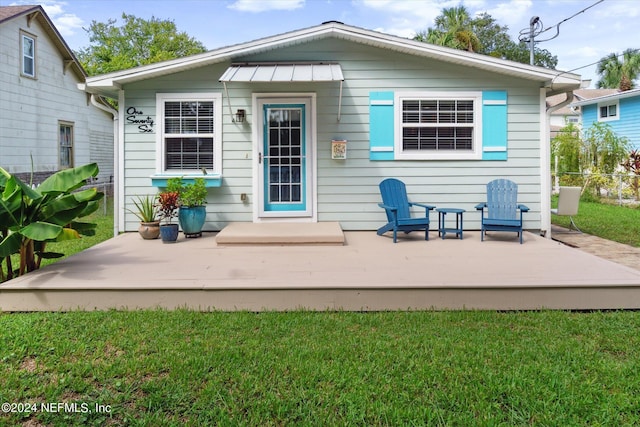 back of property with a yard and a deck