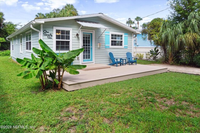 rear view of property featuring a yard