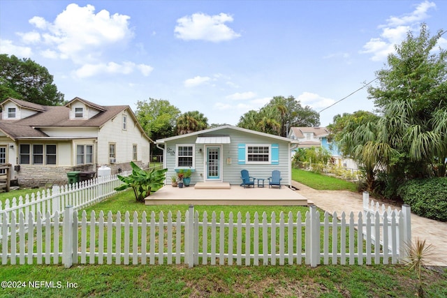 view of front of home with a front lawn, a fenced front yard, and an outdoor structure