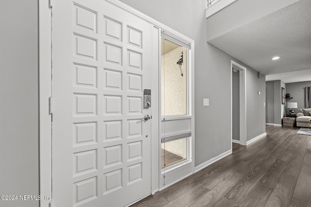 entrance foyer with dark hardwood / wood-style flooring and a textured ceiling