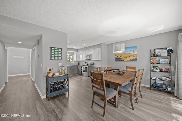 dining area featuring a textured ceiling and wood-type flooring