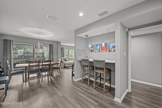 dining space with dark hardwood / wood-style flooring and a textured ceiling