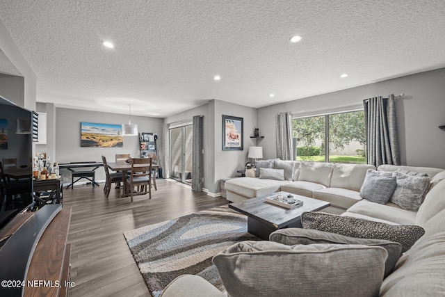 living room featuring a textured ceiling and light wood-type flooring