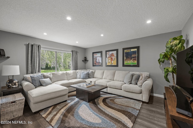 living room featuring a textured ceiling and dark hardwood / wood-style flooring