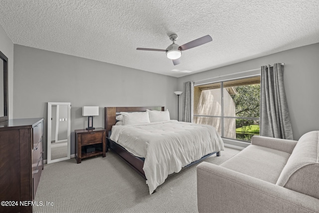 bedroom with a textured ceiling, ceiling fan, and carpet