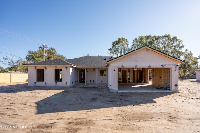 view of front of house featuring a patio, an attached garage, and fence