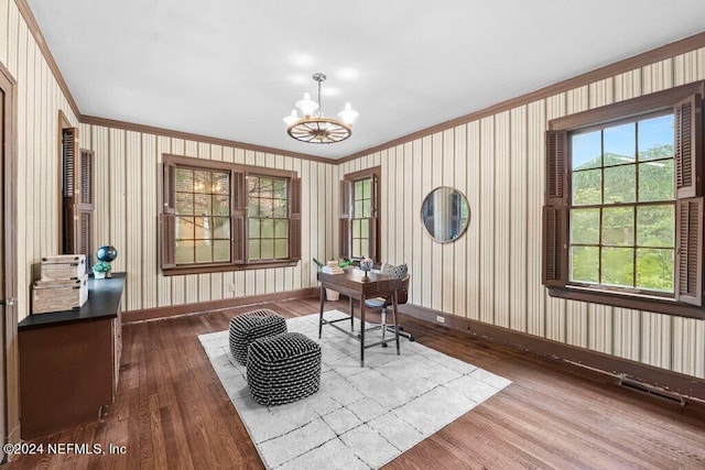 living area with ornamental molding, an inviting chandelier, and hardwood / wood-style flooring