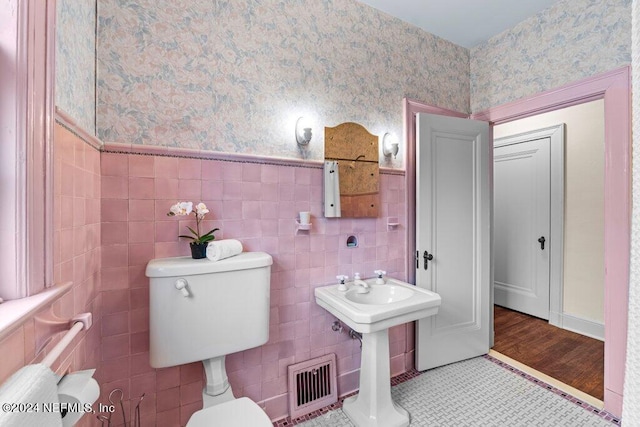 bathroom with tile walls, toilet, hardwood / wood-style flooring, and sink