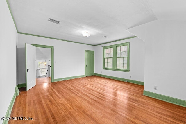 spare room featuring light hardwood / wood-style floors and vaulted ceiling