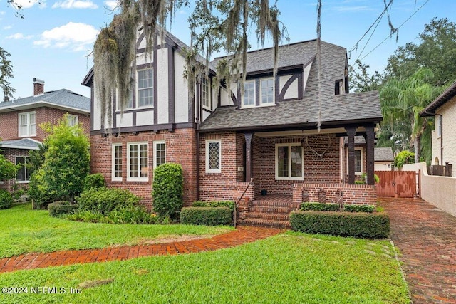 tudor-style house featuring a front yard