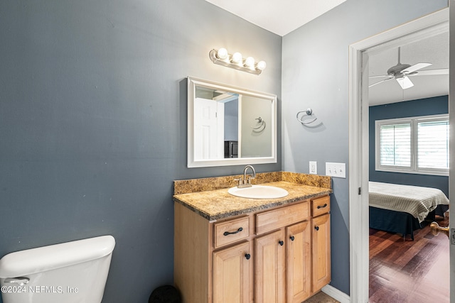 bathroom with ceiling fan, toilet, wood-type flooring, and vanity