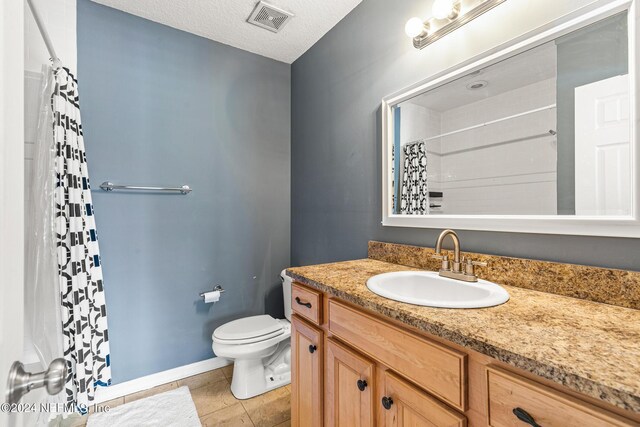 bathroom with tile patterned floors, walk in shower, toilet, vanity, and a textured ceiling