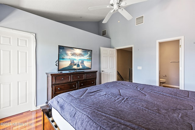 bedroom with high vaulted ceiling, ceiling fan, ensuite bath, and wood-type flooring