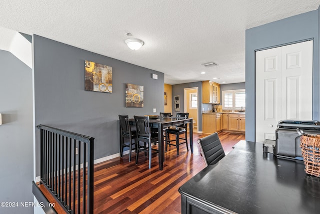 interior space featuring a textured ceiling, dark hardwood / wood-style floors, and sink