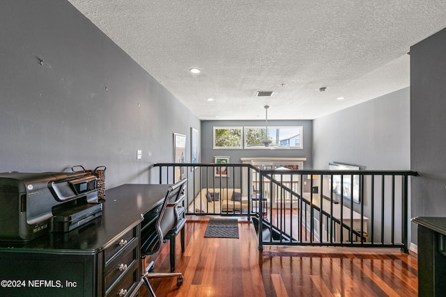 interior space with a textured ceiling and dark hardwood / wood-style floors