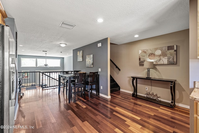 dining space featuring dark hardwood / wood-style flooring and a textured ceiling