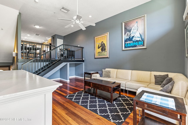 living room featuring dark wood-type flooring and ceiling fan